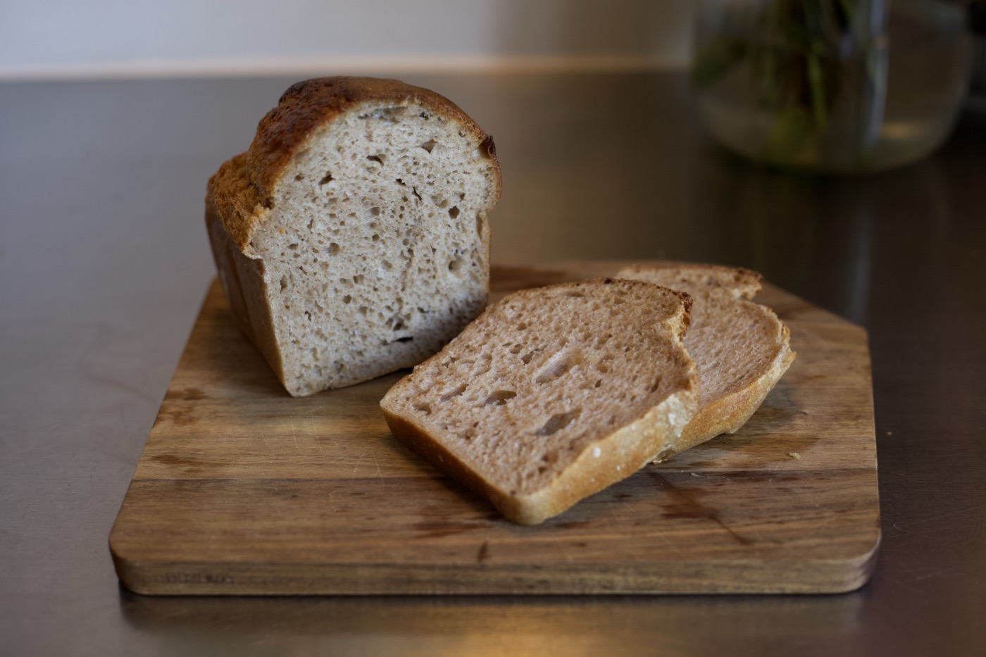 Sandwich-Bread, Laib angeschnitten, mit zwei Scheiben auf einem Holzbrett